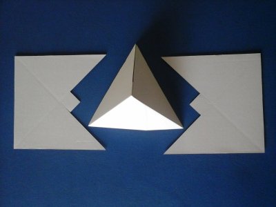 Pirâmide branca em 3D com duas peças planas brancas ao lado sobre fundo azul