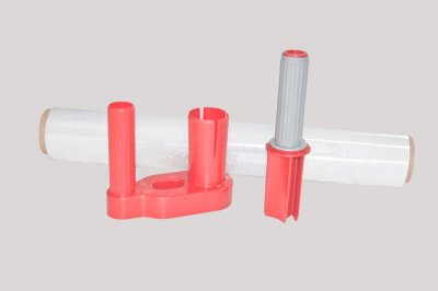 Rolo de película transparente com acessórios vermelhos e cinzentos sobre fundo cinzento