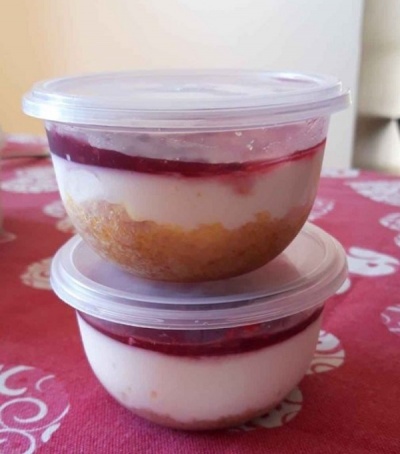 Dois recipientes transparentes com doce em camadas, base amarela, creme branco e topo vermelho.