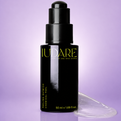 Frasco preto com doseador de peeling químico IUDARE sobre superfície roxa com gel ao lado