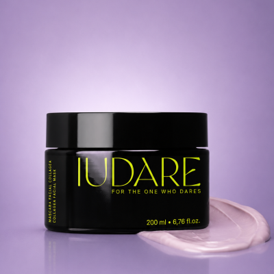 Frasco preto de máscara facial com texto amarelo em fundo roxo.