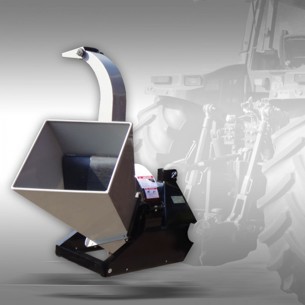 TRITURADOR DE RAMOS BX 42S Triturador de galhos metálico cinza e preto com suporte e etiquetas em fundo desfocado de trator