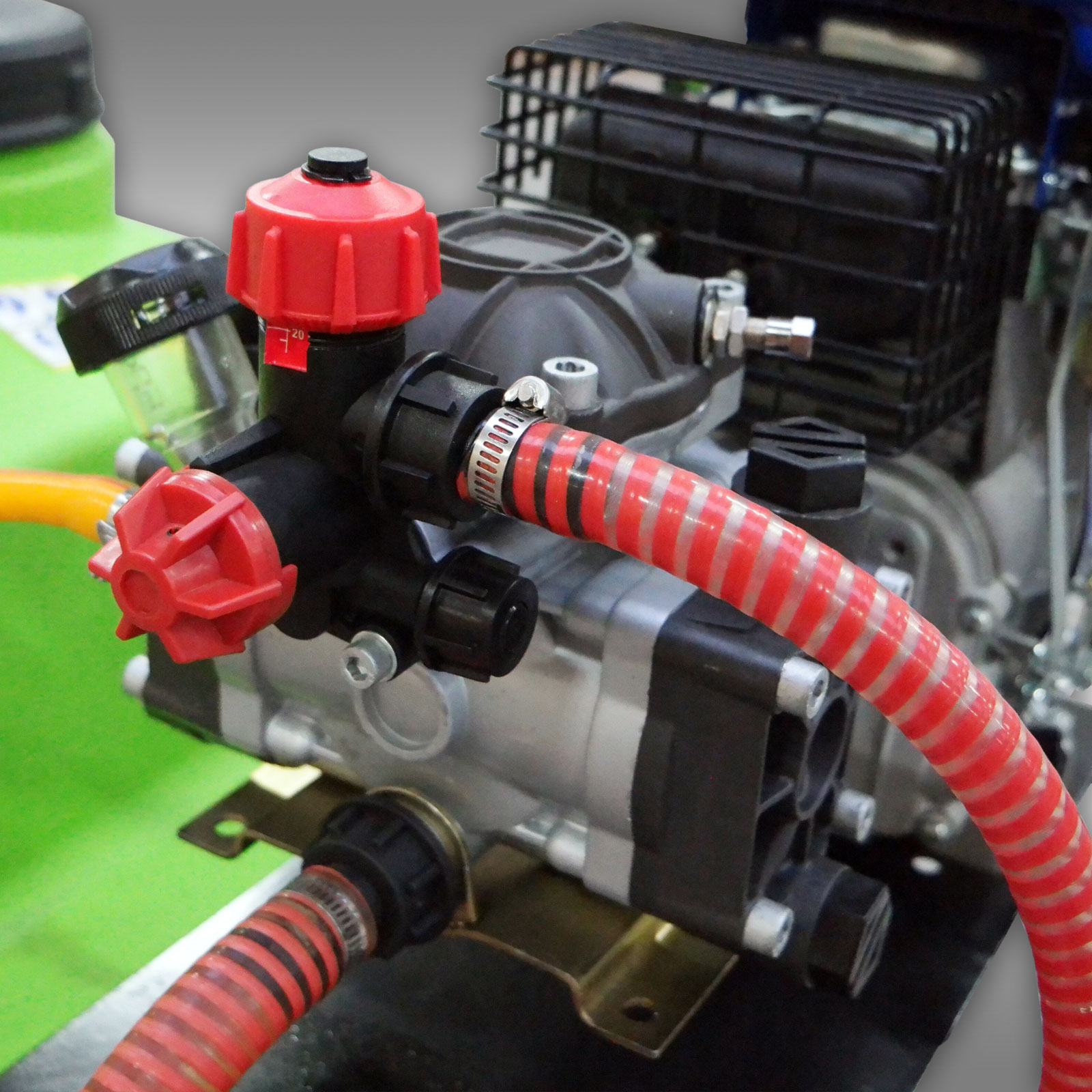 Pulverizador motorizado MGS-100 Motor com mangueira vermelha listrada e válvulas vermelhas.