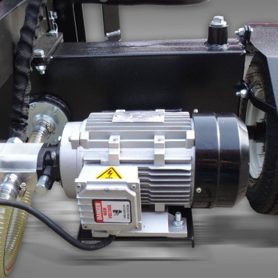 Motor elétrico cinza e preto com etiqueta de perigo em equipamento industrial