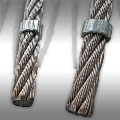 Dois cabos de aço prateados entrelaçados com grampos metálicos em fundo cinza
