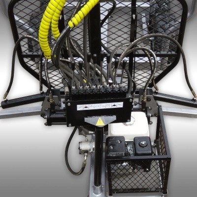 Equipamento industrial com estrutura metálica preta, mangueiras hidráulicas, motor branco e painel com avisos