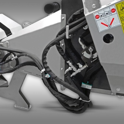 Parte de máquina industrial metálica cinzenta com cabos e etiquetas de segurança