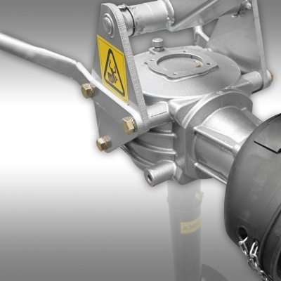 Componente mecânico metálico cinza com motor preto e etiqueta amarela de segurança