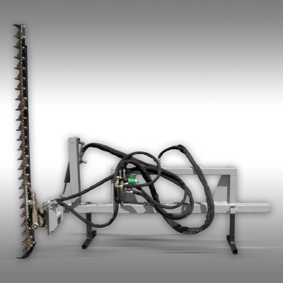 Máquina agrícola com lâmina dentada vertical e cabos pretos sobre estrutura metálica cinza.