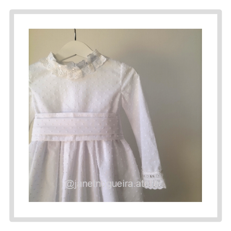 Vestido Iria Vestido branco infantil com renda e bolinhas pendurado em cabide