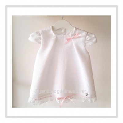 Vestido branco de bebé com laços cor-de-rosa e renda na bainha