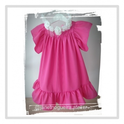 Vestido infantil rosa com mangas franzidas e babado na barra pendurado