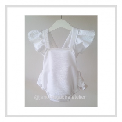 Fato de banho branco com folhos para bebé pendurado