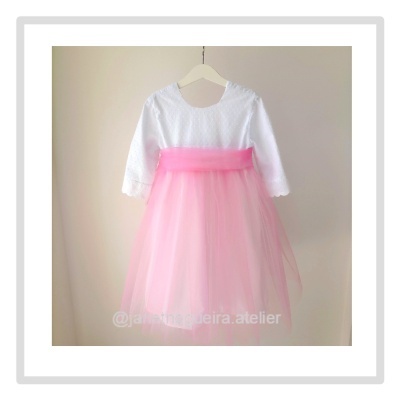 Vestido infantil branco e rosa com saia em tule pendurado