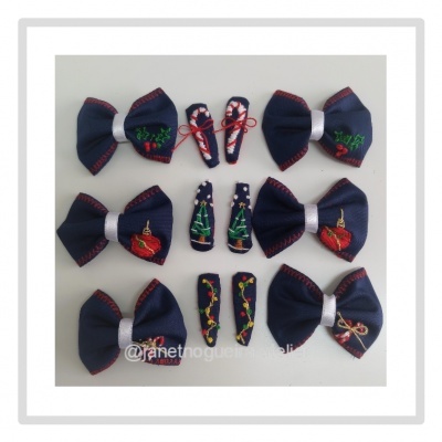 Conjunto de acessórios em tecido azul escuro com bordados coloridos, laços e presilhas