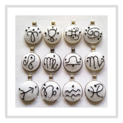 Doze pendentes redondos com símbolos de signos do zodíaco em branco e preto