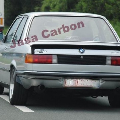 Carro BMW 323i prata visto de trás numa estrada com texto Jasa Carbon