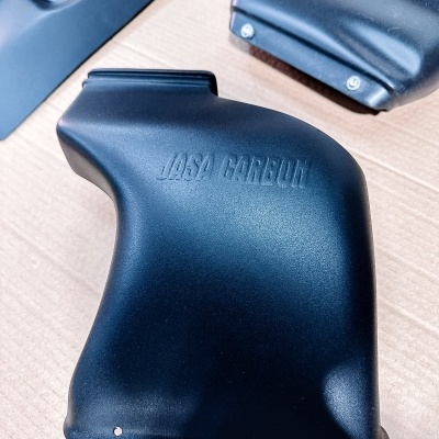 Peças automóveis pretas com texto JASA CARBON e detalhes em relevo