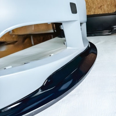 Spoiler frontal de automóvel branco e preto sobre superfície branca