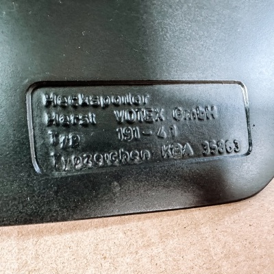 Placa de metal preta com texto gravado em relevo