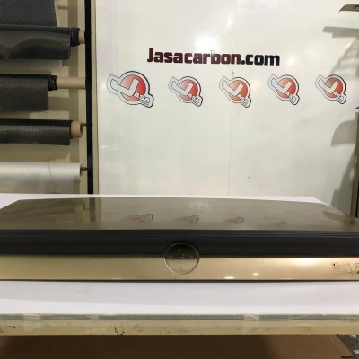 Expositor de vidro escuro e base bege numa mesa branca em armazém com texto a fundo