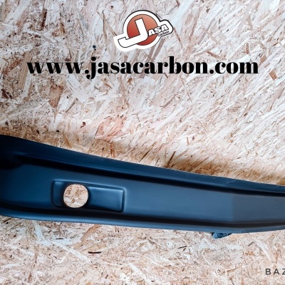 Peça automóvel preta alongada sobre superfície de madeira com texto www.jasacarbon.com e logótipo J ASCA