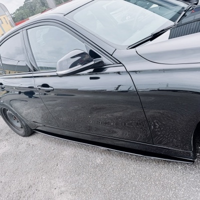 Carro preto de quatro portas estacionado num parqueamento