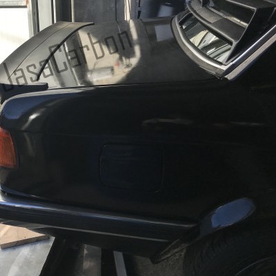 Traseira de carro preto com pára-choques cromado e luz traseira laranja