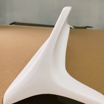 Base branca triangular em plástico sobre superfície castanha com fundo branco e logos.