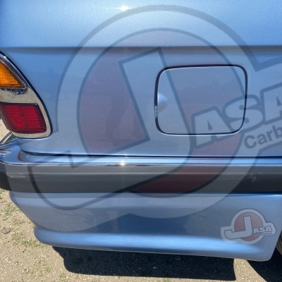 Detalhe da traseira de carro azul claro com pára-choques, farol e etiqueta J ASA Carbon