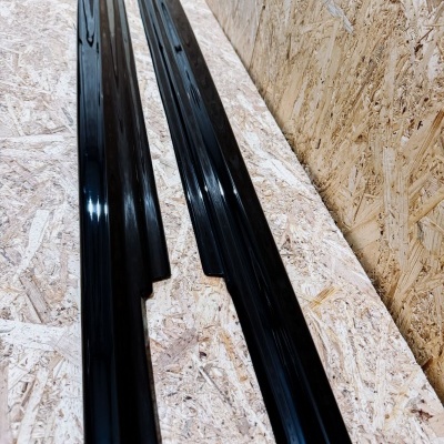 Duas peças pretas brilhantes sobre superfície de madeira clara