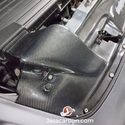 Cobertura de motor em carbono para carro com textura de fibra de carbono preta e estrutura cinzenta.