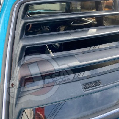 Vidro traseiro de carro azul com veneziana preta e emblema FIAT X1/9