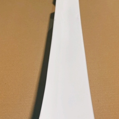 Peça branca longa com recortes e texto www.JasaCarbon.com em fundo castanho