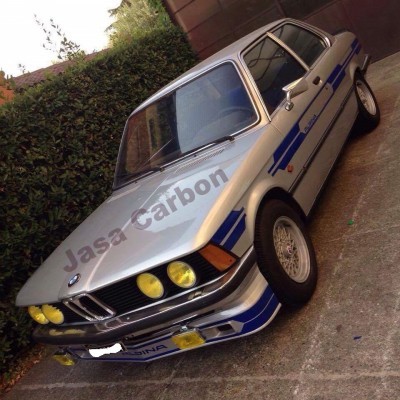 Carro desportivo clássico BMW prateado com detalhes azuis e amarelos