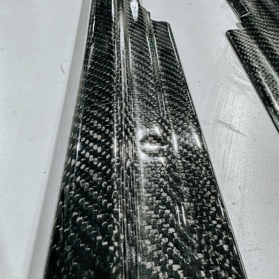 Peças longas de fibra de carbono com padrão característico sobre fundo branco