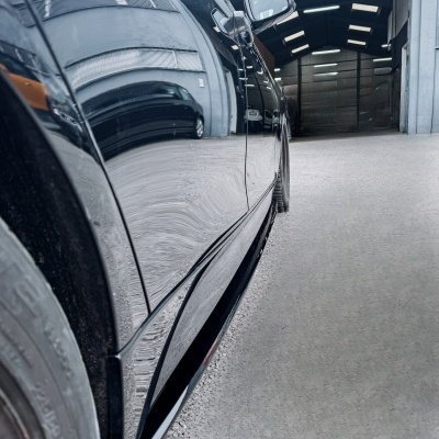 Lateral de carro preto refletindo garagem