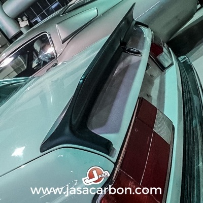 Carro branco com spoiler traseiro preto estacionado em garagem interior