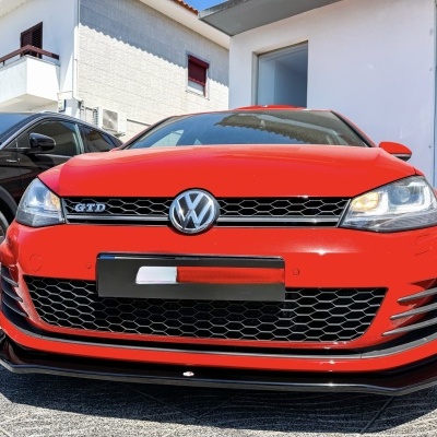 Carro Volkswagen GTD vermelho estacionado junto a edifício branco