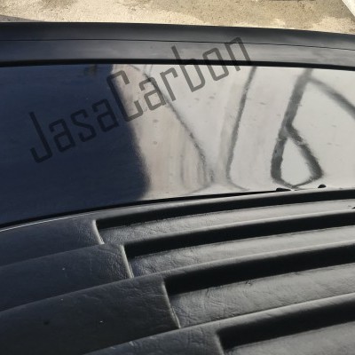 Parte traseira do veículo preto com persianas e texto JasaCarbon no vidro