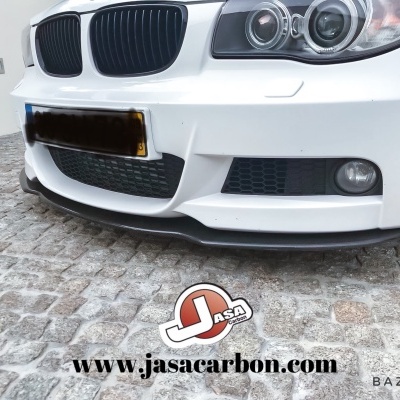 Parachoques dianteiro branco de BMW com grelha preta e faróis duplos sobre calçada