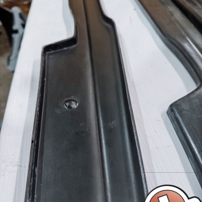 Peças negras alongadas em plástico ou borracha sobre superfície branca com autocolante JASH Carbon BAZAART