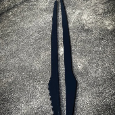 Dois objetos pretos longos num chão cinzento