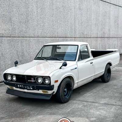 Carrinha pick-up branca clássica estacionada junto a parede cinzenta com logo Jasa no chão