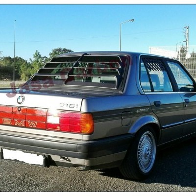 Carro BMW 316i cinzento escuro com jantes de liga leve e grade nas janelas traseiras