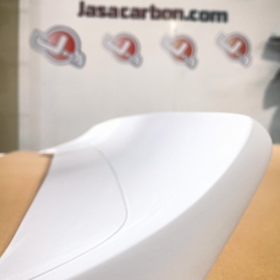 Spoiler traseiro branco sobre mesa com texto BMW E30 XL e parede com logo e texto jasacarbon.com