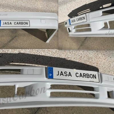 Para-choques branco de automóvel em chão de pedra com texto JASA CARBON