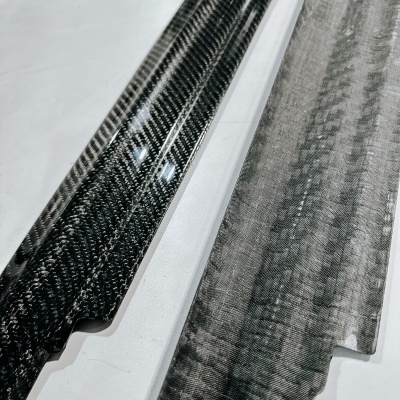 Dois painéis de fibra de carbono, um brilhante e outro fosco, com padrão entrelaçado