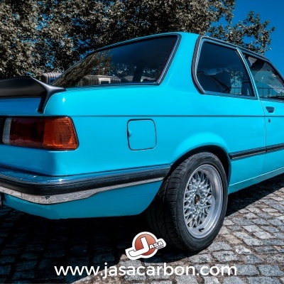 Carro BMW clássico azul turquesa coupé duas portas com spoiler traseiro preto e jantes prata