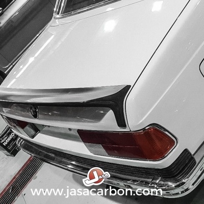 Traseiro de carro clássico branco com spoiler preto e luzes vermelhas na garagem